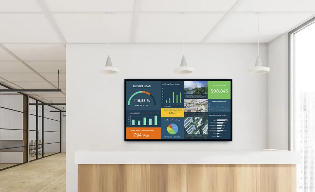 A business dashboard on a screen above an office reception desk.