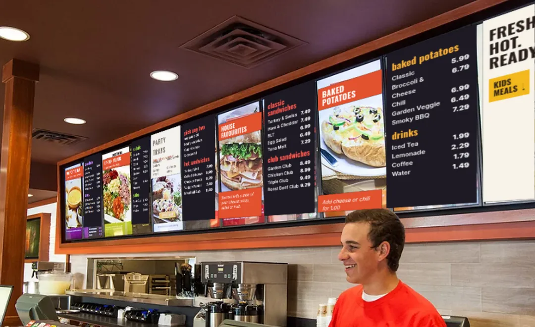 Digital menu boards above the counter of a sandwich restaurant.